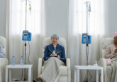 3 women with cancer sit on comfortable hospital chairs receiving IV treatments. To represent that the EU urges clear guidance for JCA cancer treatments